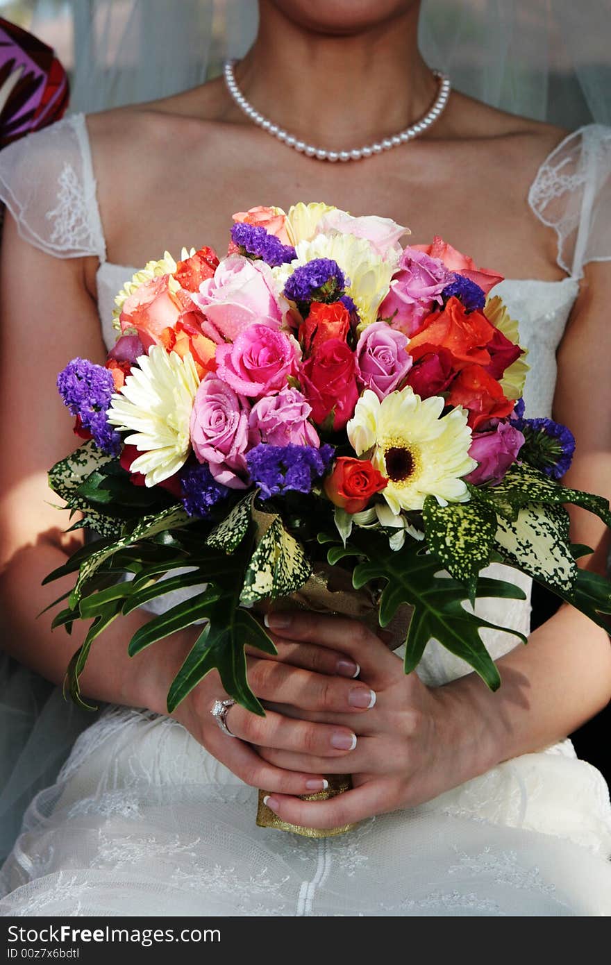 Close-up of a bride holding a wedding bouquet.