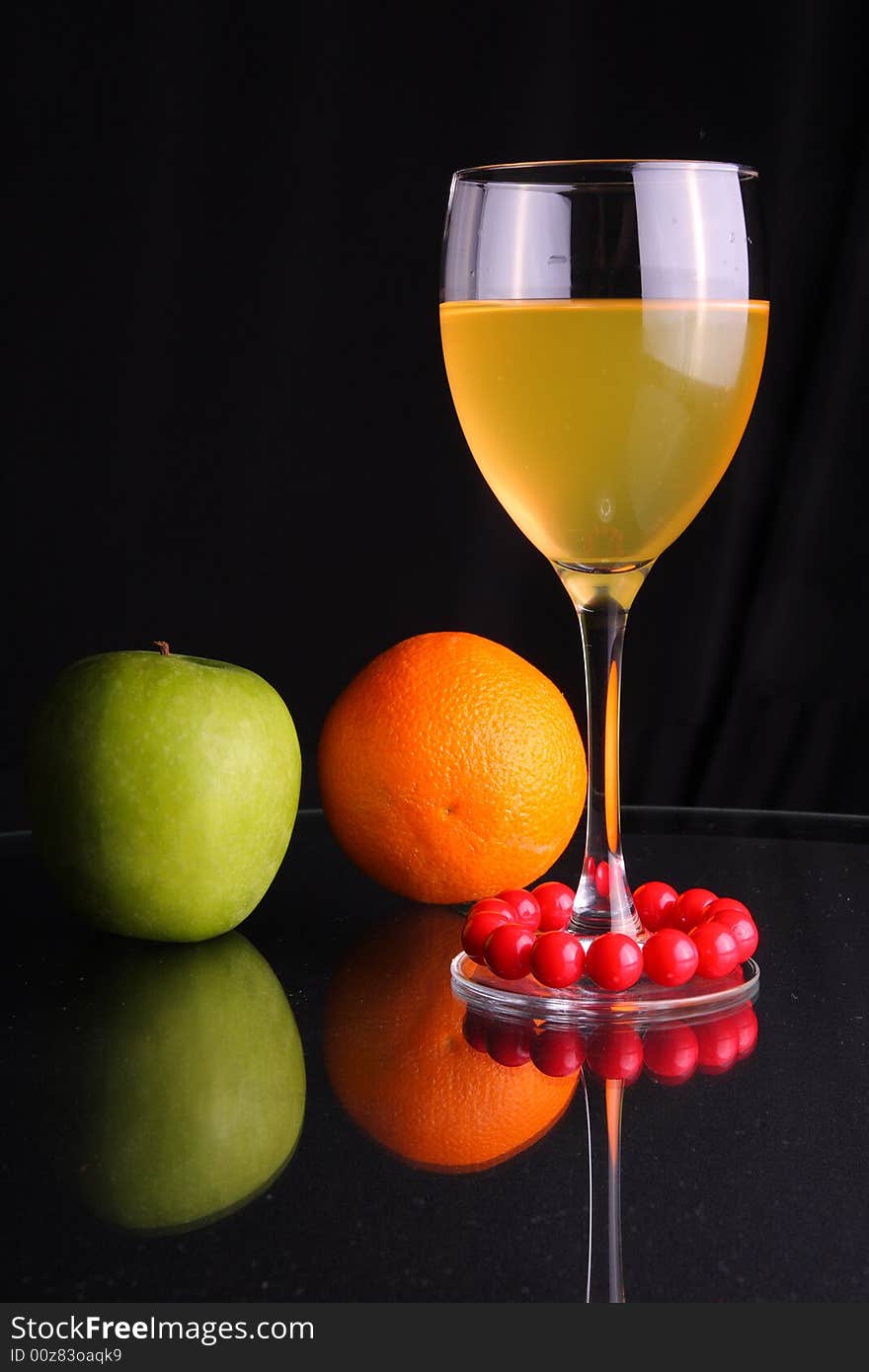 Fruit juice in glass, apple, orange and reflection