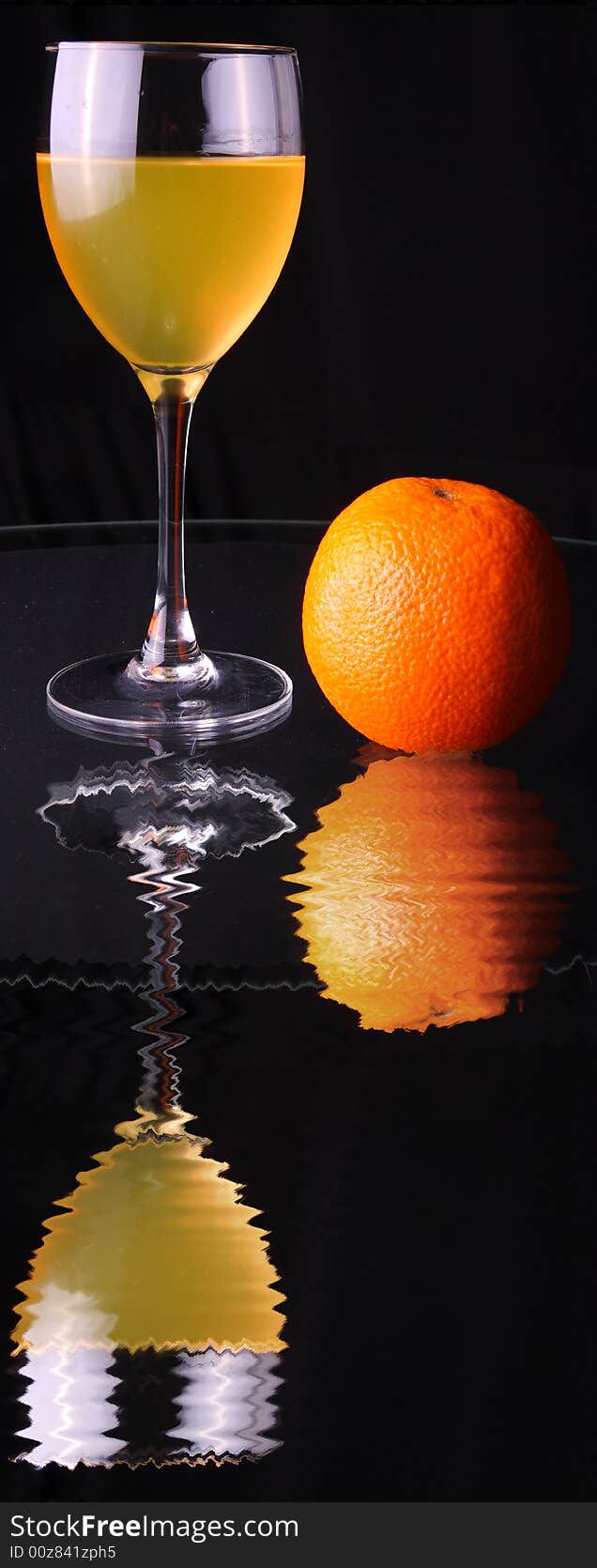 Fruit juice in glass, apple, orange and reflection