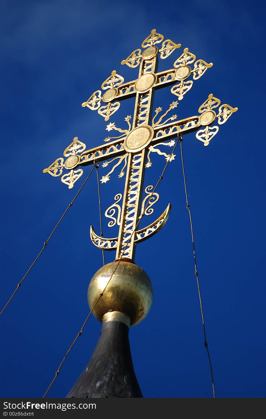 Gold Christian cross on a background of the blue sky. Gold Christian cross on a background of the blue sky