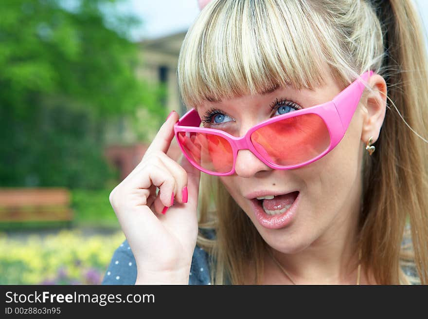 Beauty wonder blonde girl in pink glass with open mouth in th city