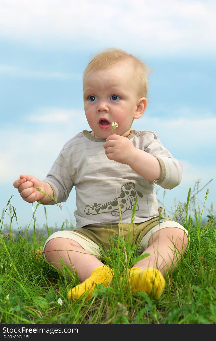 Little baby  on green grass with flower