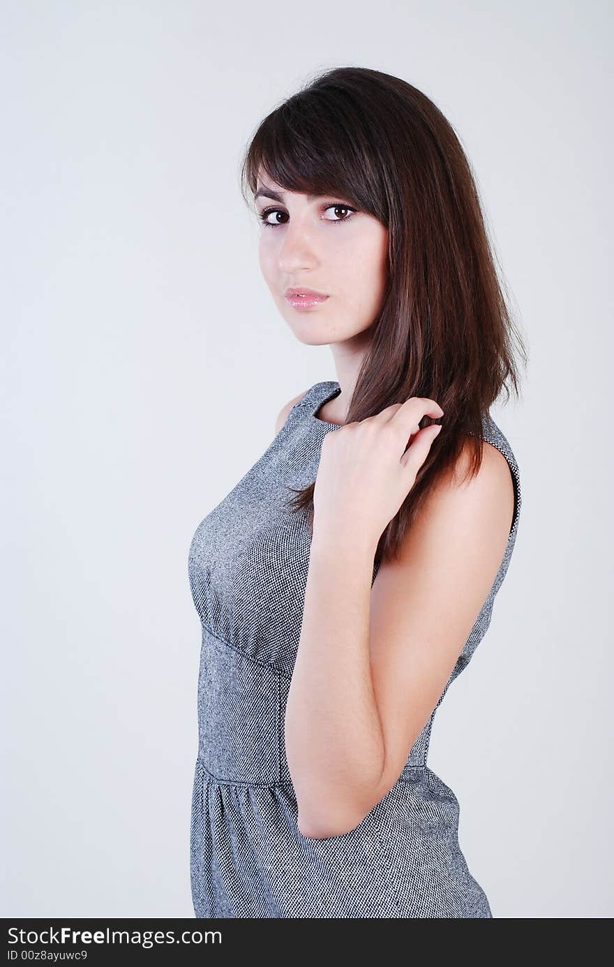 Young beautiful girl in grey clothes on a white background. Young beautiful girl in grey clothes on a white background