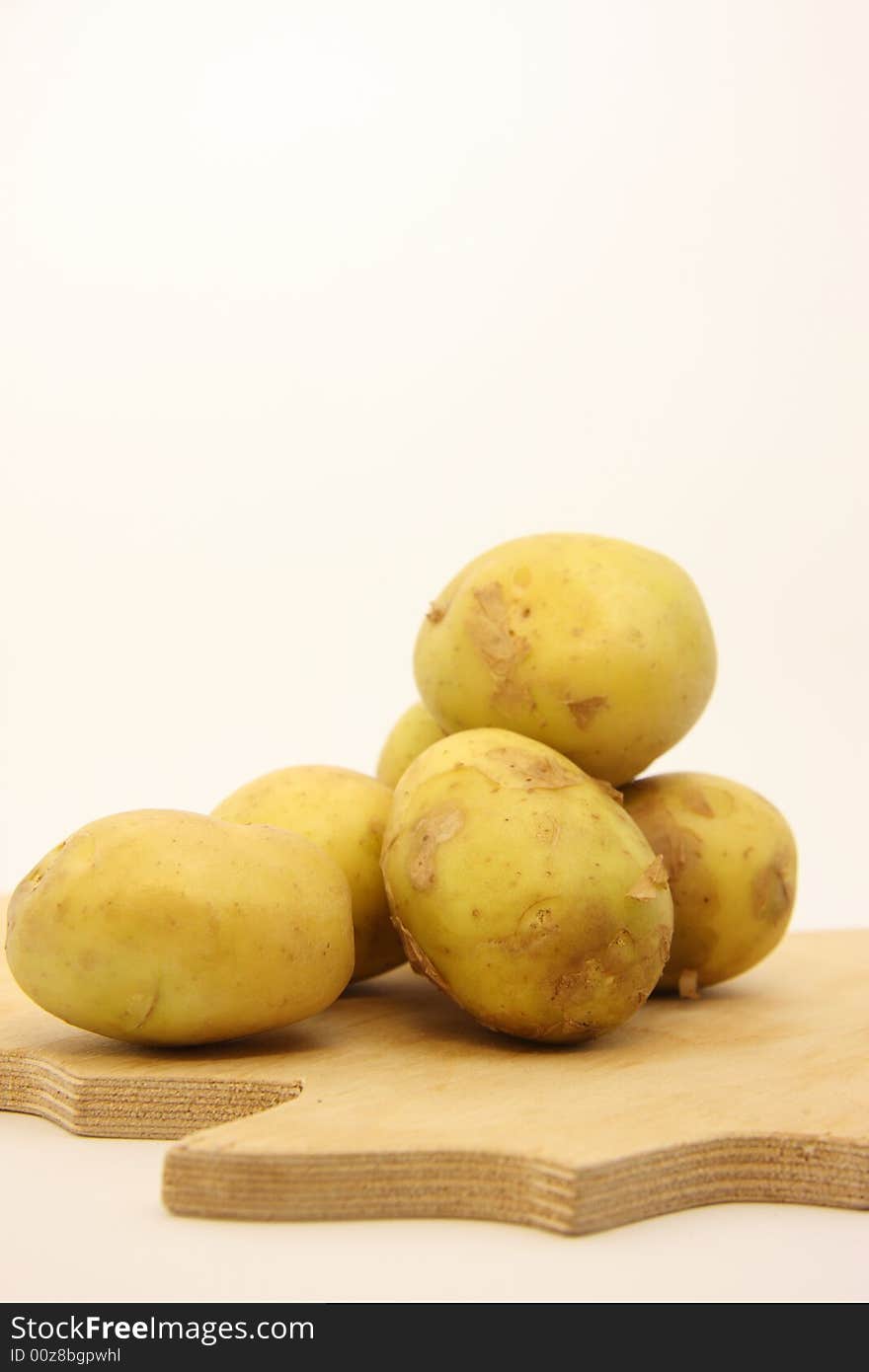 Potatoes on isolated white background over wooden kitchen board