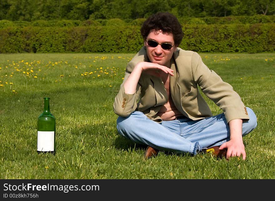 Cheerful drunk man on a meadow