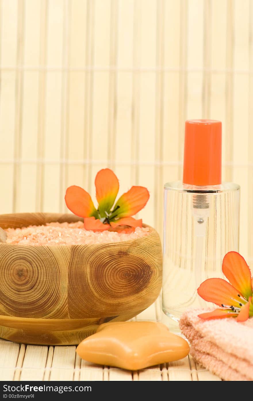 Fragrance bottle, bath salt, soap and towel with decoration flowers on bamboo. Fragrance bottle, bath salt, soap and towel with decoration flowers on bamboo