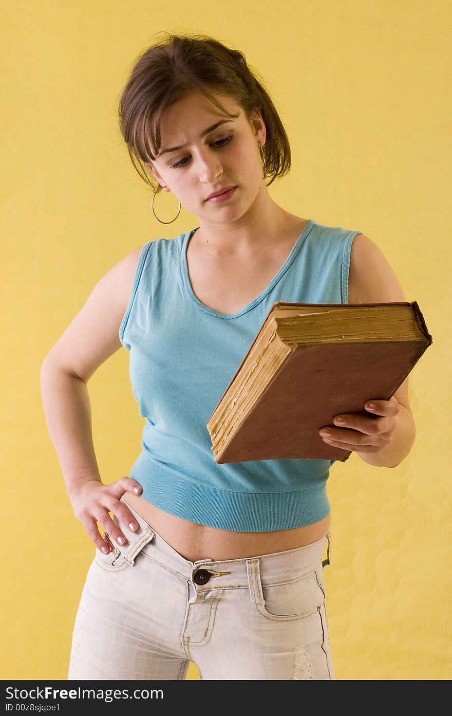 Young student girl holding her books on yelow backgrounds