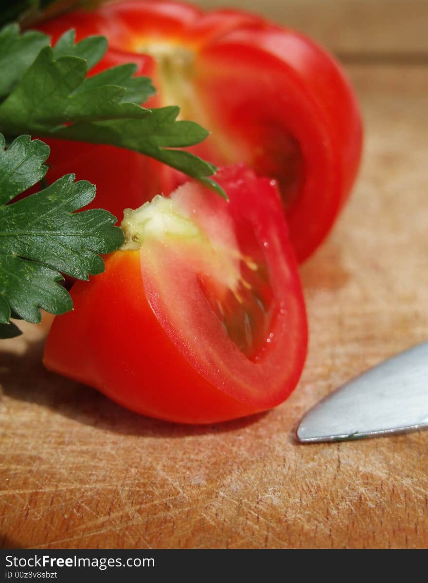 A sliced tomato on a wooden cutting board. A sliced tomato on a wooden cutting board.