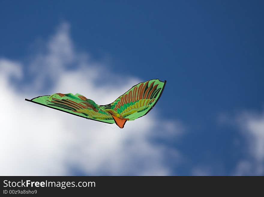 Green kite flying in the blue sky. Green kite flying in the blue sky