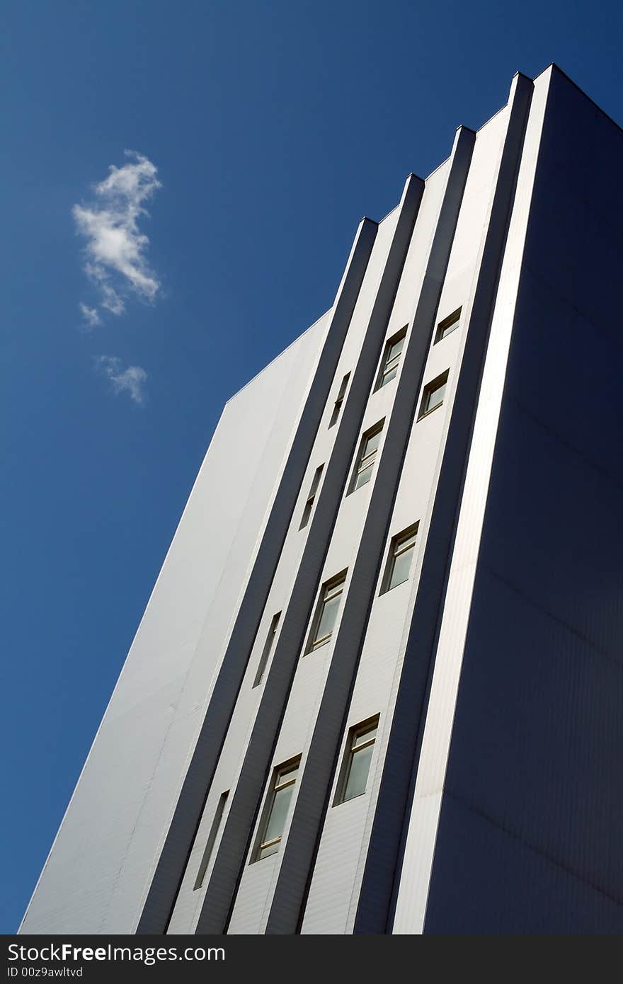 Net blue sky, single white cloud. Modern building.