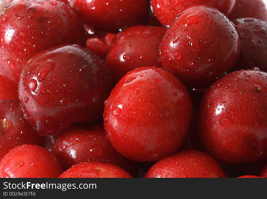 A lot of fresh red cherry with drops on background