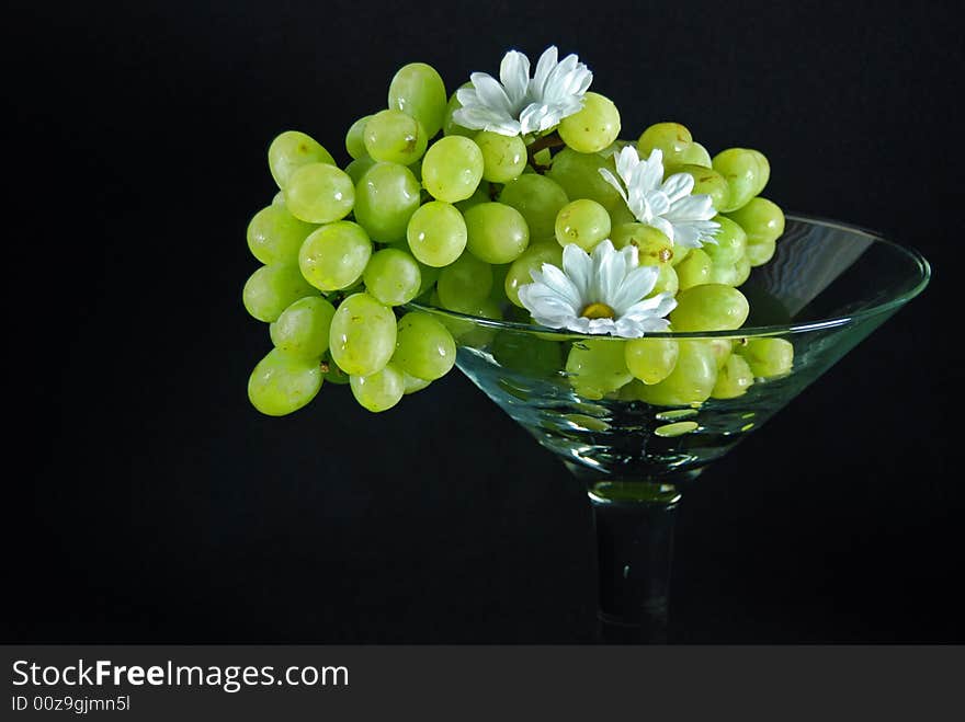 Green grapes and summer daisies in a large glass. Green grapes and summer daisies in a large glass.