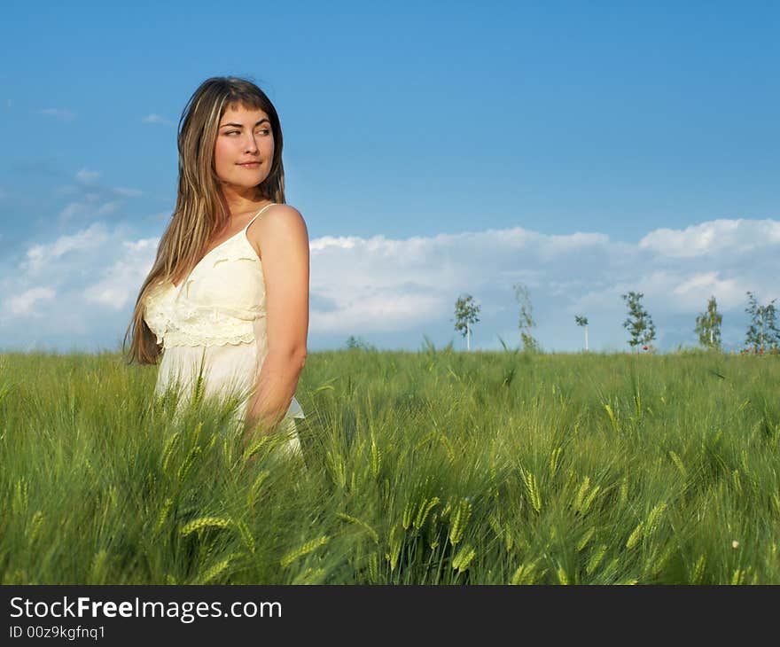 Beautiful young woman in grean field looking right. Beautiful young woman in grean field looking right