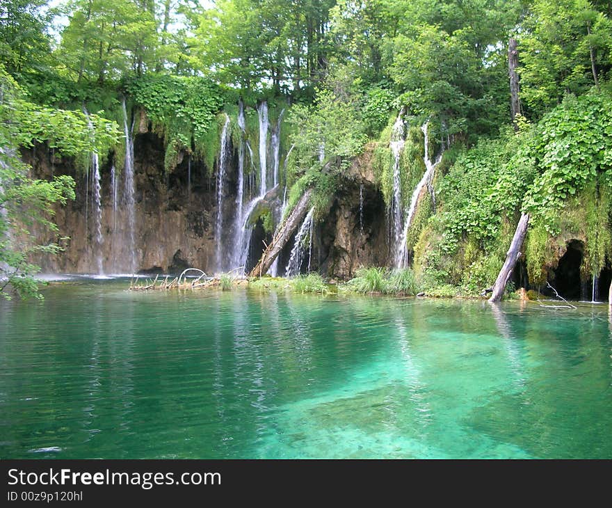 Picture of a tropical lake with green trees, waterfalls clear water and sharp cliffs. Picture of a tropical lake with green trees, waterfalls clear water and sharp cliffs