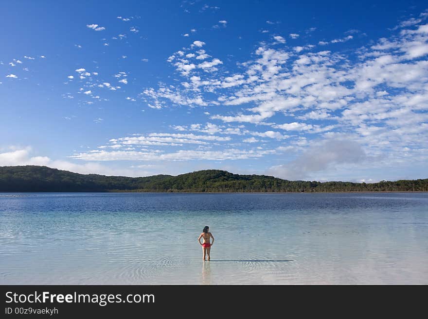 Young girl standing in the tranquil lake