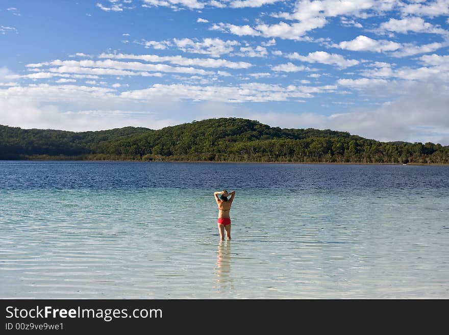 Young girl standing in the tranquil lake