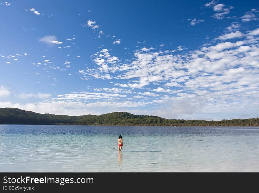 Young girl standing in the tranquil lake