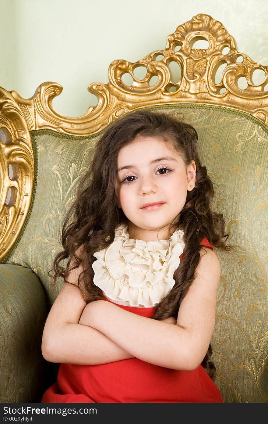 Small girl with long hair in the armchair. Small girl with long hair in the armchair