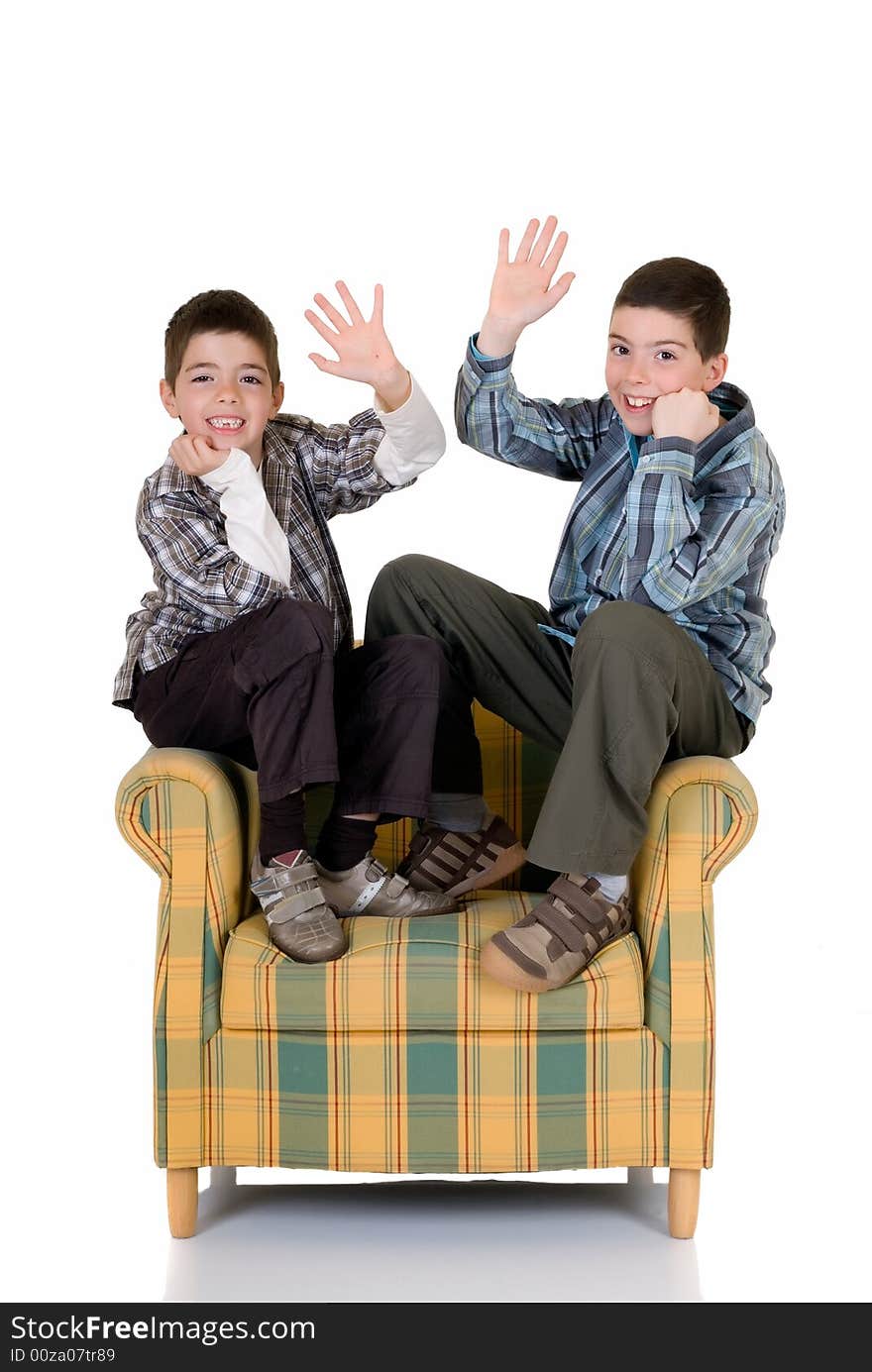 Two young happy smiling boys sitting on the back of the chair. Two young happy smiling boys sitting on the back of the chair