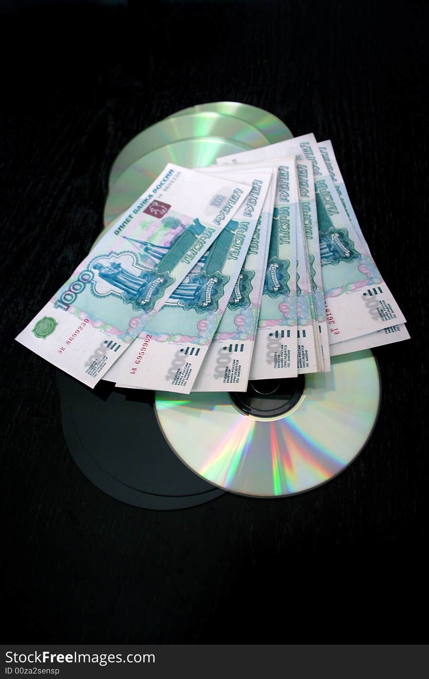 Bills by value 1000 roubles and computer disks for keeping of information on dark background