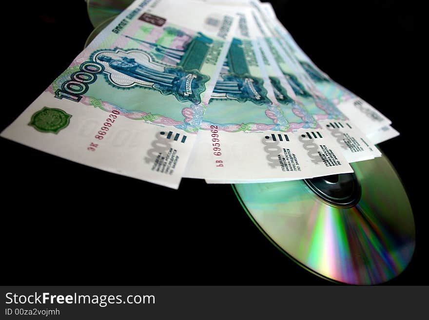 Bills by value 1000 roubles and computer disks for keeping of information on dark background