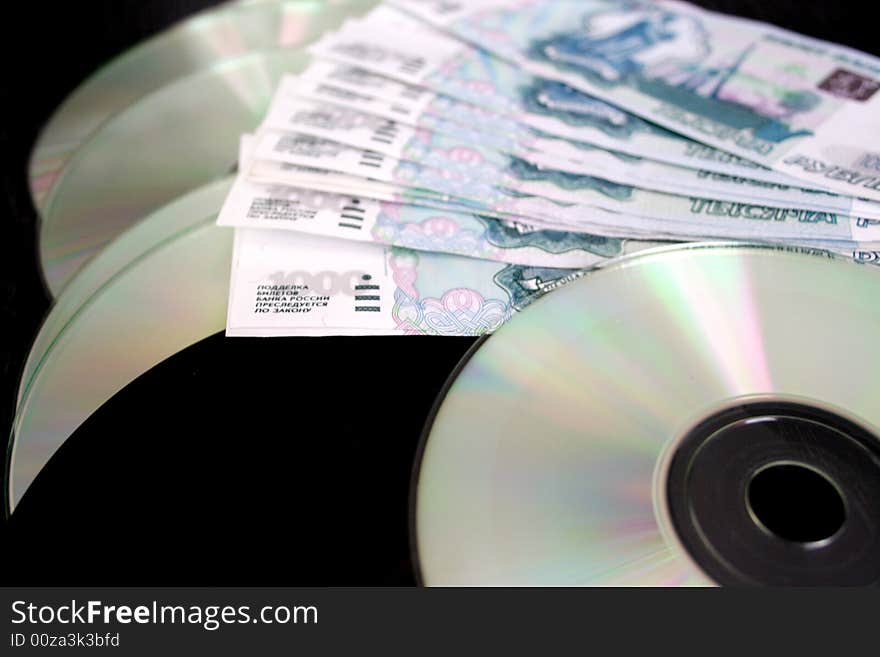 Bills by value 1000 roubles and computer disks for keeping of information on dark background