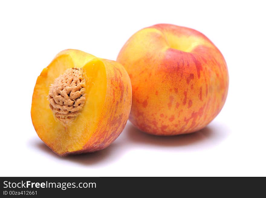 Whole and half peach on white background. Whole and half peach on white background