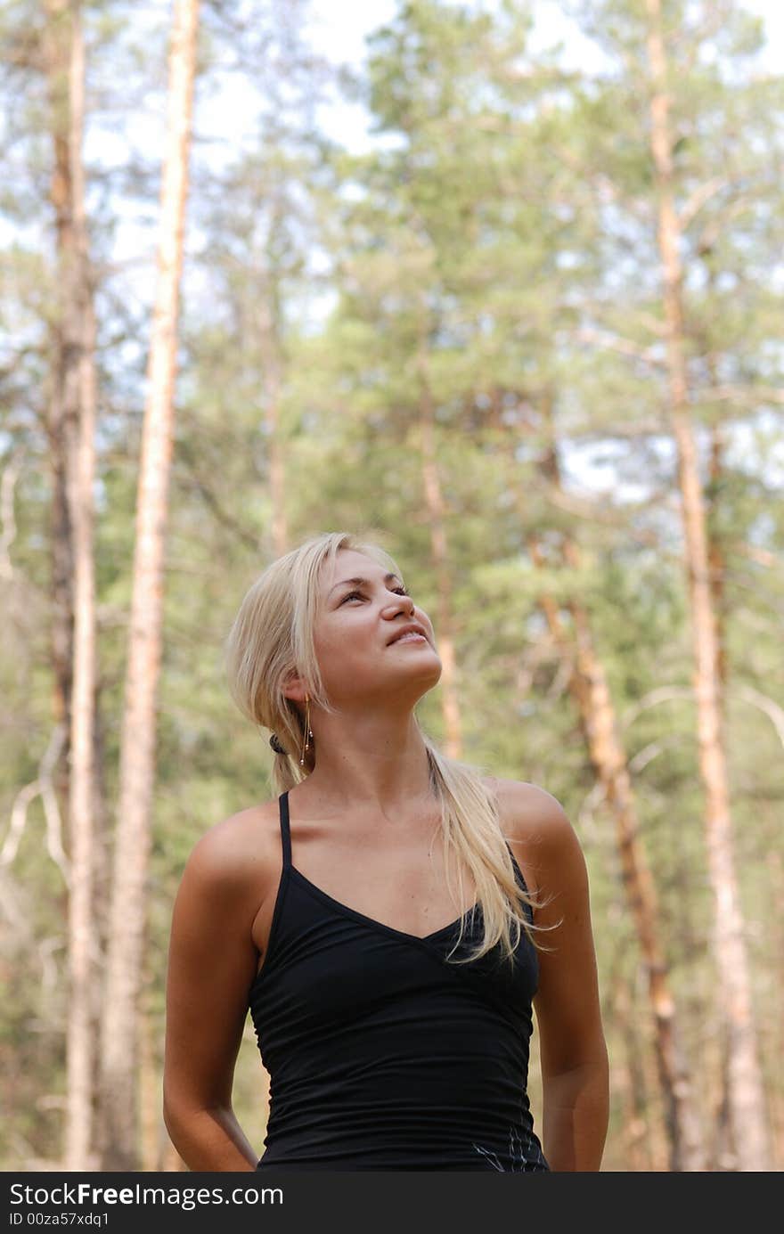 The girl  blonde. In a black blouse and a happy smile on the person. The girl  blonde. In a black blouse and a happy smile on the person