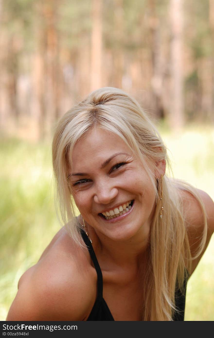 The girl  blonde. In a black blouse and a happy smile on the person. The girl  blonde. In a black blouse and a happy smile on the person