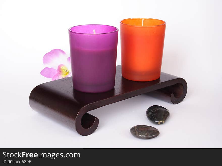 Color candles and pebbles in white background