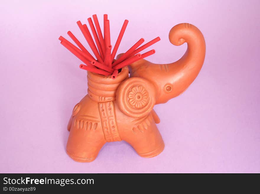 Incense sticks on  elephant holder in color background