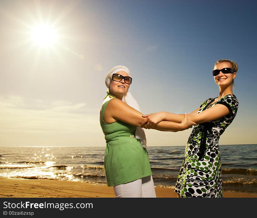 Two beautiful women sitting on the beach