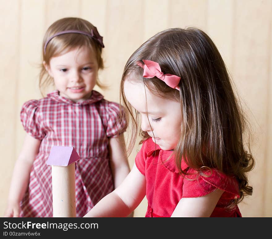 Portrait of two little girls building toy tower