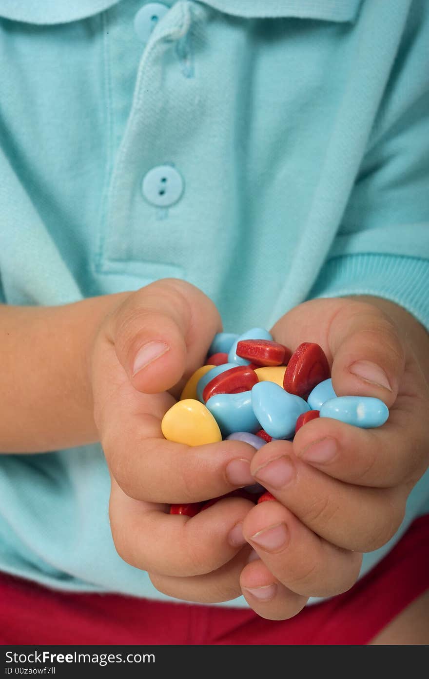 Closeup of young boy hands holding heart shaped candies. Closeup of young boy hands holding heart shaped candies