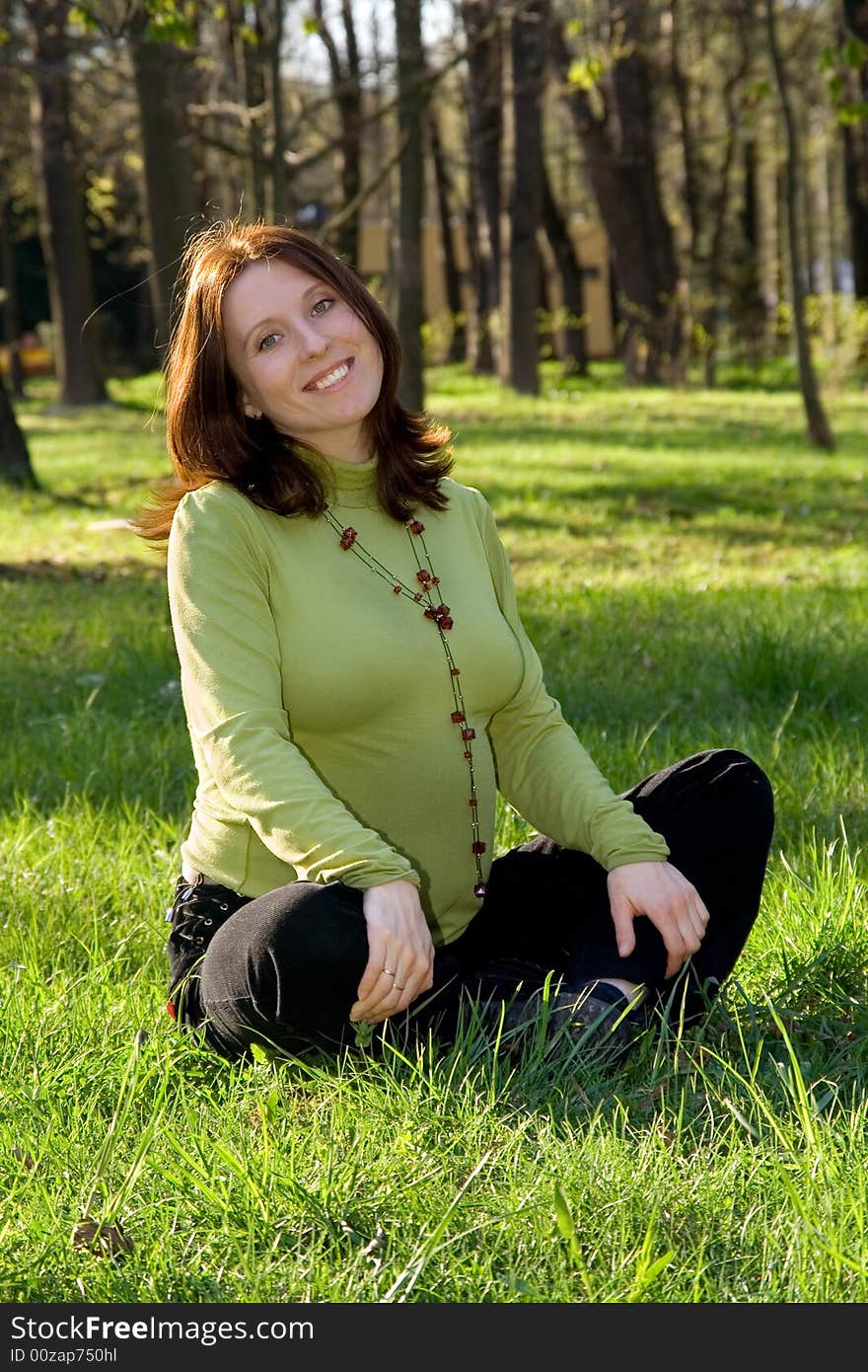 Expectant mother on a grass in park