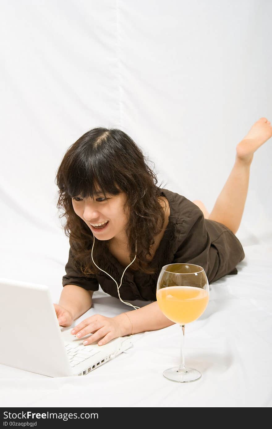 A asian female adolescent in brown skirt with light brown curved hair is enjoying the chatting with her online friends. White she is also enjoying the orange juice. A asian female adolescent in brown skirt with light brown curved hair is enjoying the chatting with her online friends. White she is also enjoying the orange juice.