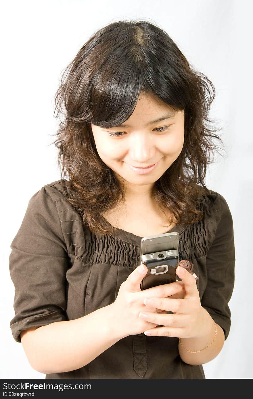 A girl is sending a short message through her slide type hand phone. A girl is sending a short message through her slide type hand phone.