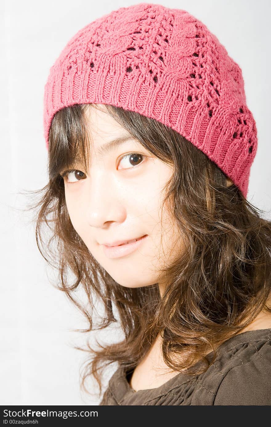 A cute asian girl wearing a pink and red hat. A cute asian girl wearing a pink and red hat.