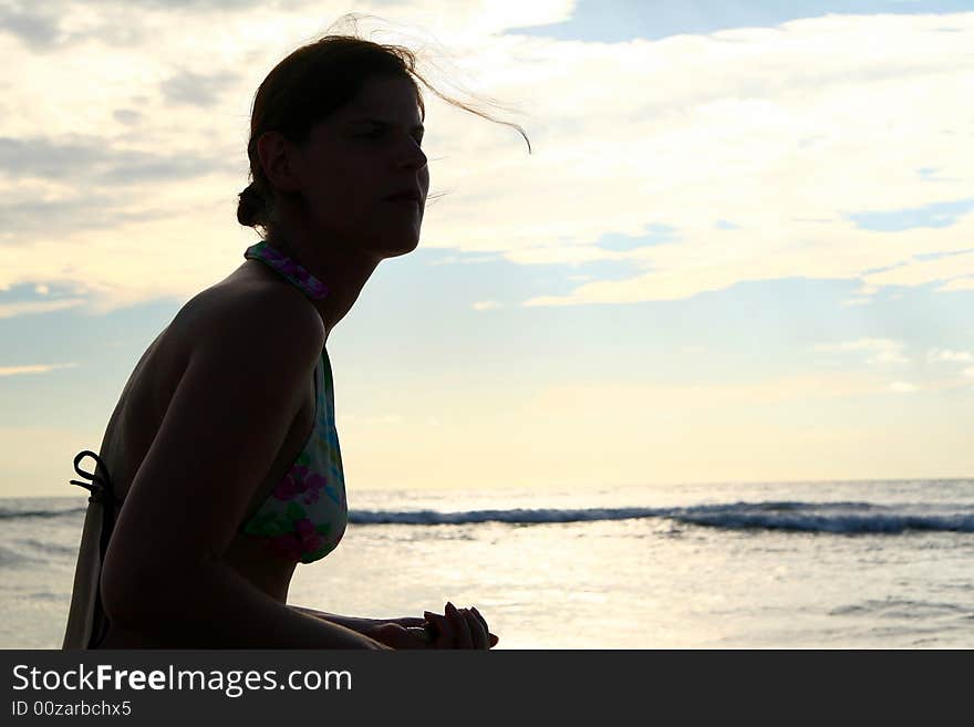 The silhouette of a young woman at the beach. Ideal vacation shot. The silhouette of a young woman at the beach. Ideal vacation shot.