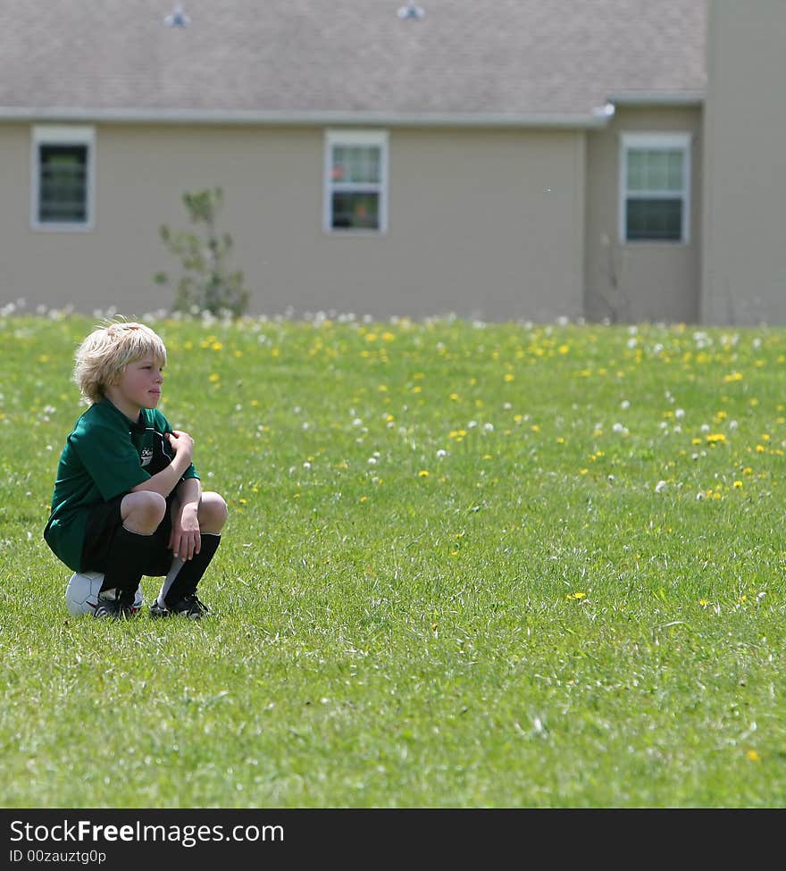 Young boy waiting for the sign to go in and play soccer. Young boy waiting for the sign to go in and play soccer