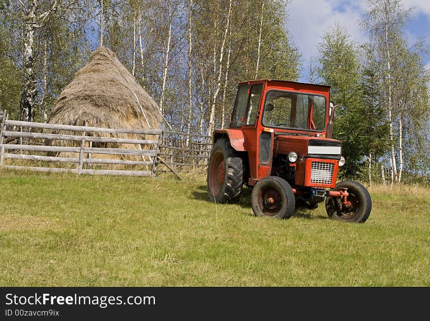 Image of a tractor in a mountain rural area.