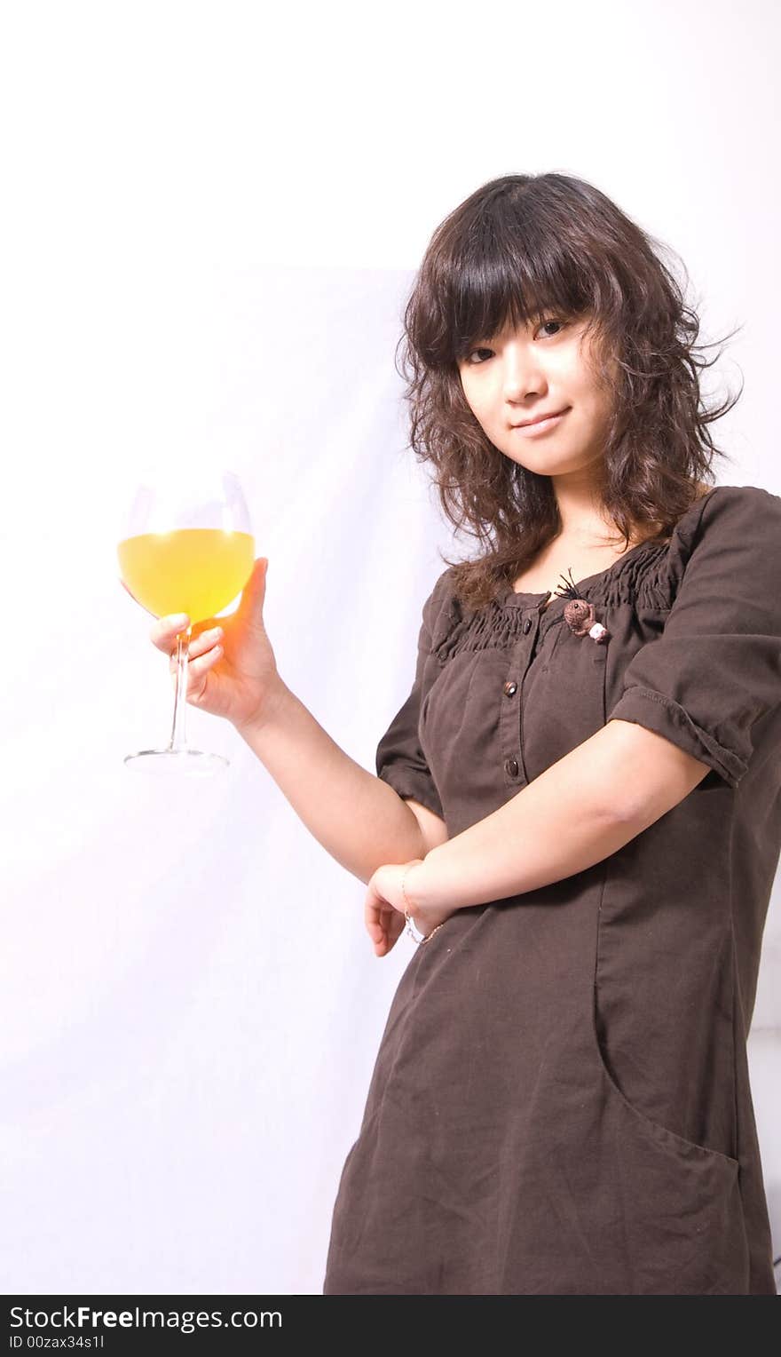 A young fashionable girl holding a red wine glass with orange juice inside. A young fashionable girl holding a red wine glass with orange juice inside