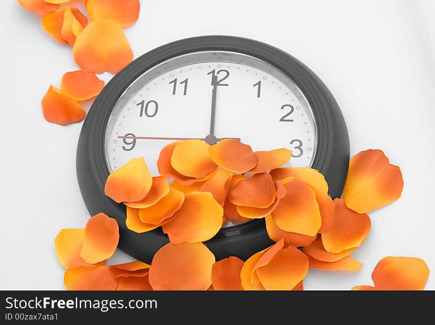 A clock submerged in bright orange and red petal. A clock submerged in bright orange and red petal