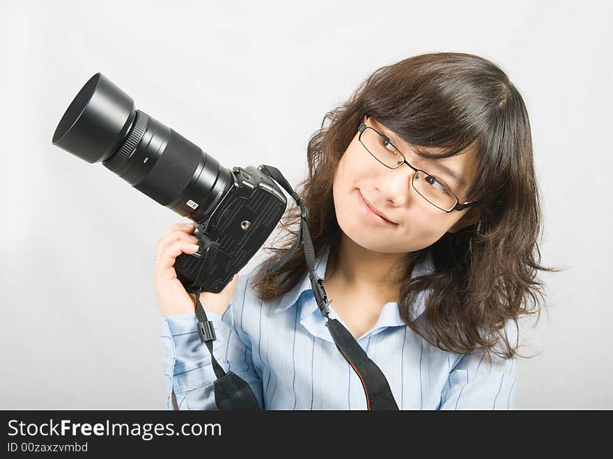 A young female photographer is holding a profession black digital camera. A young female photographer is holding a profession black digital camera