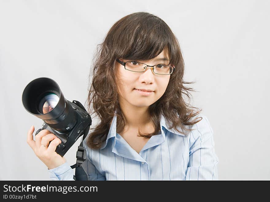 A young female photographer is holding a profession black digital camera. A young female photographer is holding a profession black digital camera