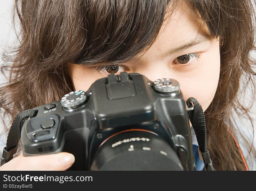 A close up photo of a young female photographer when she is looking through the viewfinder. A close up photo of a young female photographer when she is looking through the viewfinder.