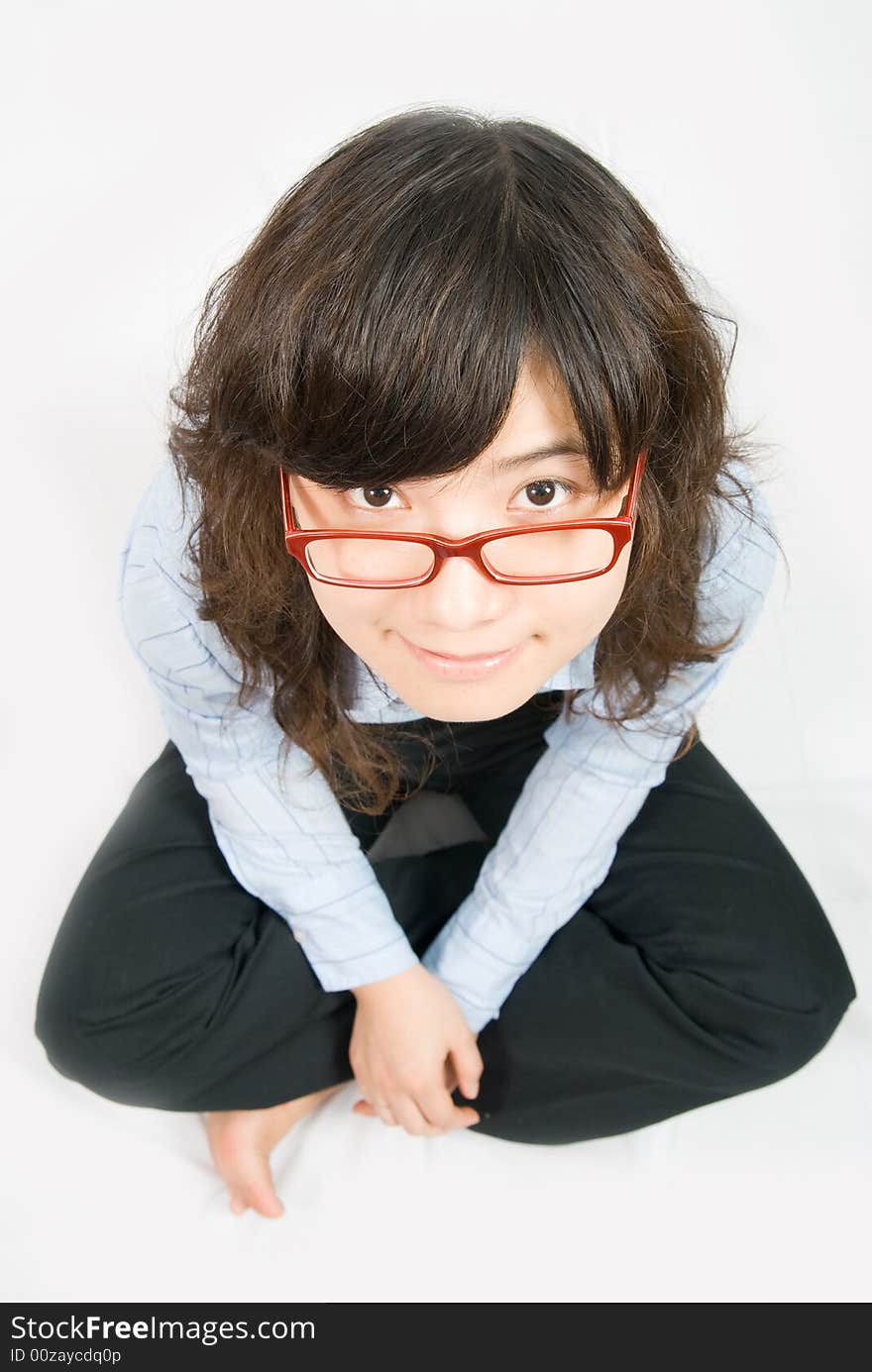 A very cute girl wearing red frame glass and light blue shirt is looking forward