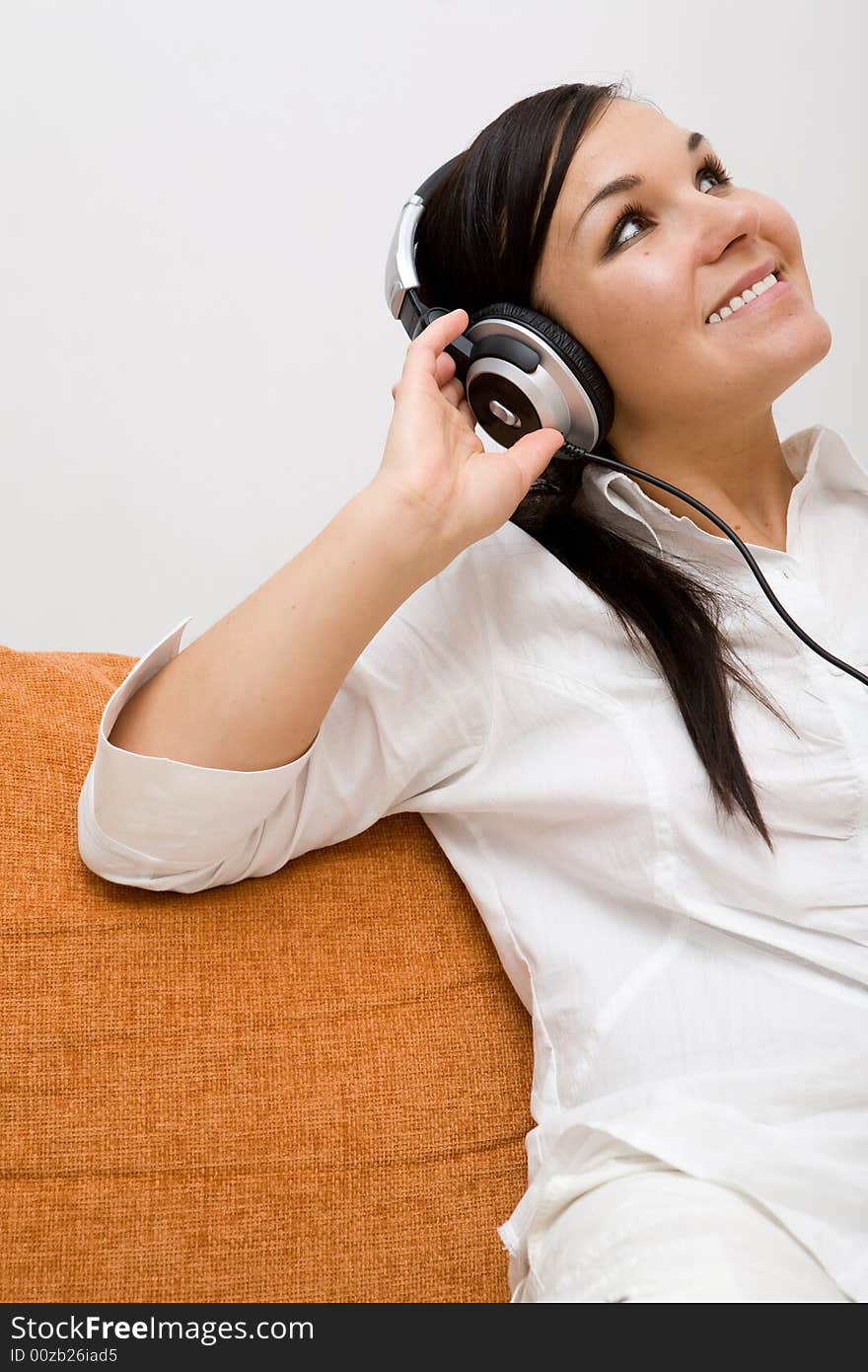 Attractive woman with headphones on sofa. Attractive woman with headphones on sofa