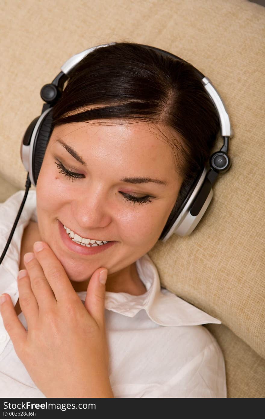 Attractive woman with headphones on sofa. Attractive woman with headphones on sofa