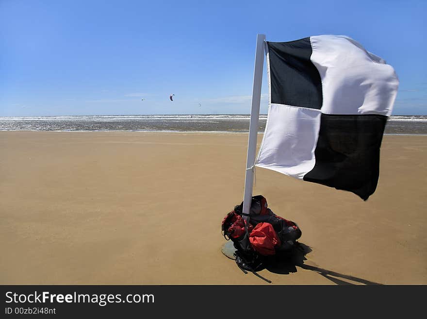 Beach Scene with Kitesurfing and black and white checkered flag. Beach Scene with Kitesurfing and black and white checkered flag